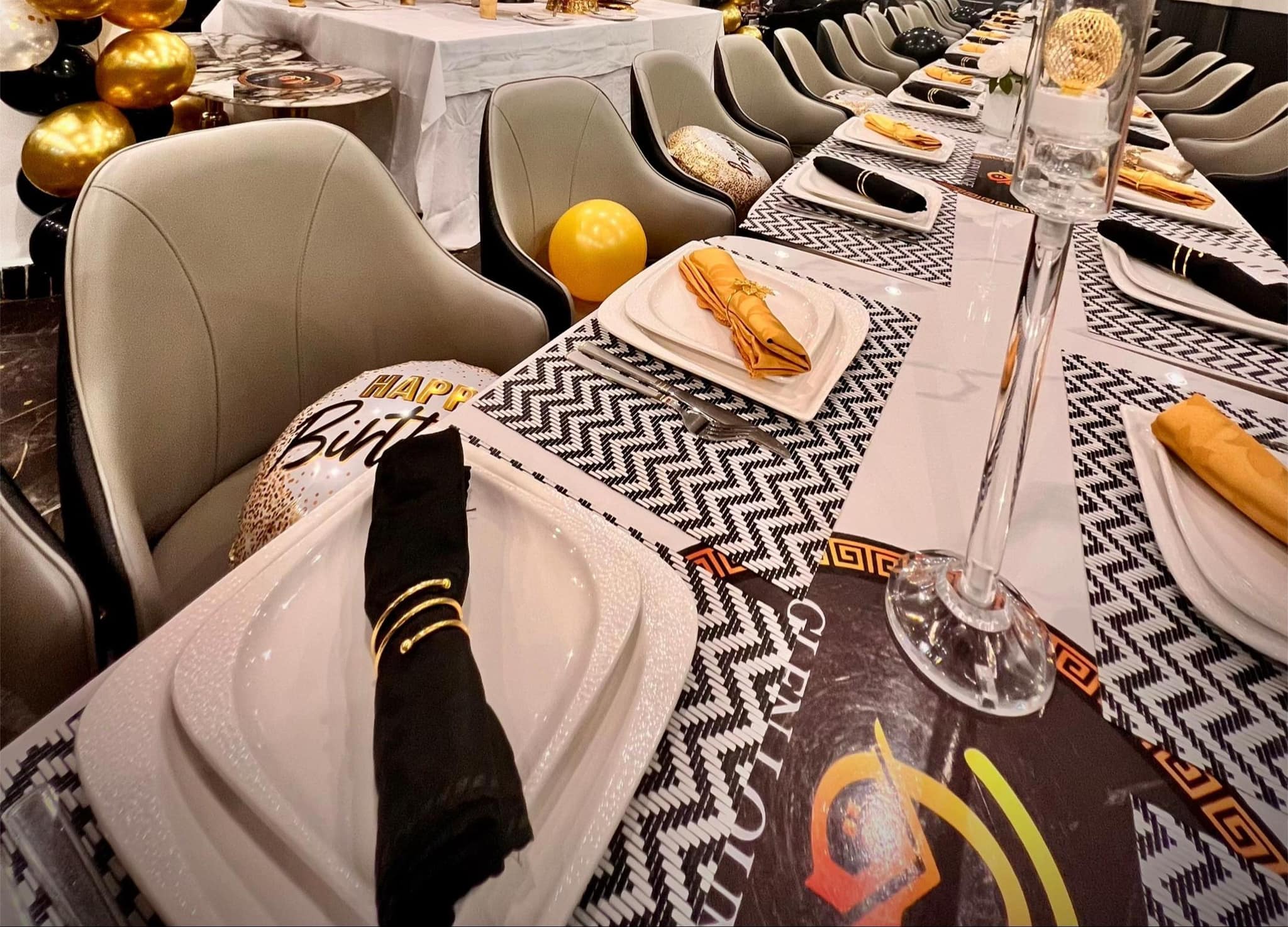 Couvert dressé — set brandé Glen Lounge, serviette nouée d’un anneau doré, ballon d’anniversaire